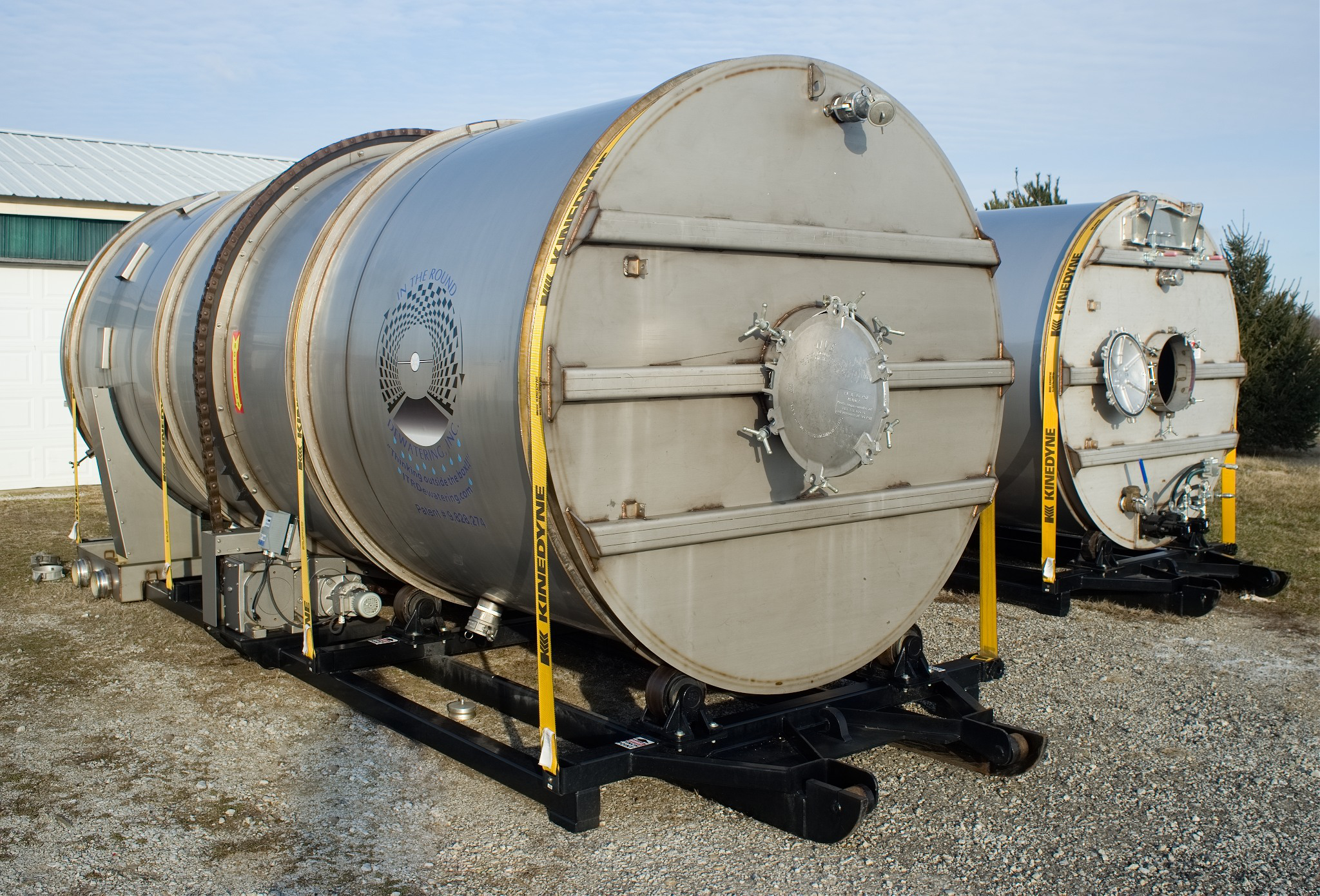 Dewatering drums are mounted on a roll-off frame for easy transport